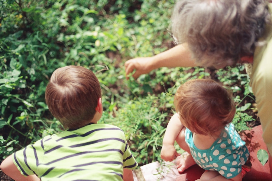 A grandmother showing her grandchildren something in the garden, seen from behind